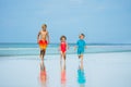 Three children boys and girl run together on sand beach Royalty Free Stock Photo