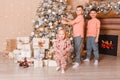 Three children decorate a large Christmas tree