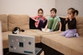 Three children with kitten sitting on the living room watching movie or cartoon from laptop Royalty Free Stock Photo