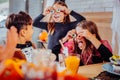 Three children with painted faces wearing costumes having Halloween party