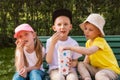 Three children in the park on a bench eating popcorn together, friends, family Royalty Free Stock Photo