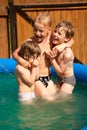 Three children play in inflatable pool Royalty Free Stock Photo
