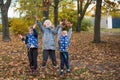 Three children are playing with fallen leaves. Royalty Free Stock Photo