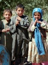 Three children pose for photos at a nomad settlement in central Afghanistan