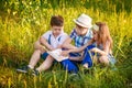 Three children read together in the summer. Brother and sister portrait in the village Royalty Free Stock Photo