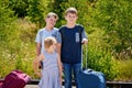 Three children, school boys and preschool girl with suitcases before leaving for summer vacation camp. Happy kids Royalty Free Stock Photo