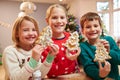 Three Children Showing Decorated Christmas Cookies