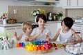 Three children, sibling brothers, painting easter eggs for decoration