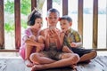 Three children sit and watch the smartphone happily. young boys and girls with cellphone communication. on the terrace of their