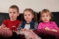 Three children on sofa 2 watching tv Royalty Free Stock Photo