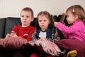 Three children on sofa watching tv Royalty Free Stock Photo