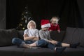 Three children are waiting for Santa Claus at home by the Christmas tree. Christmas Eve Royalty Free Stock Photo