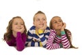 Three children wearing winter pajamas looking up smiling Royalty Free Stock Photo