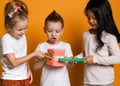 Three childrens with toothbrushes and a kissuos mock-up with zooms stand over yellow background walL Royalty Free Stock Photo