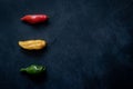 Three chili peppers, red, yellow, green, with a copy space Royalty Free Stock Photo