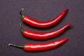 Three chilies on a grey background