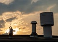 Three chimneys on a rooftop at sunset Royalty Free Stock Photo