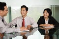 Three Chinese businesspeople in a meeting