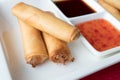 Three Chinese pancakes stuffed on a white plate with sweet chili sauce. Shallow depth of field Royalty Free Stock Photo