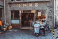 Three chinese restaurant workers sitting on chairs on street of Beijing in front of a restaurant