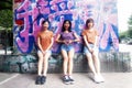 Three chinese woman posing against graffiti