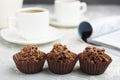 Three chocolate candies in focus with nuts and topping with cafe Royalty Free Stock Photo