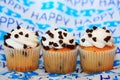 Three chocolate chip cupcakes on happy birthday background