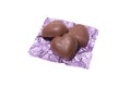 Three chocolate heart candy in puple foil on white background