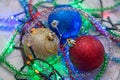 Three Christmas balls golden, blue and red with the colorful garland and tinsel Royalty Free Stock Photo