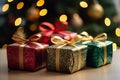 three christmas gift boxes sitting on a table in front of a christmas tree Royalty Free Stock Photo