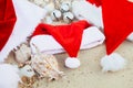 Three christmas hats on the beach. Santa hat the sand near shells. Family holiday. New year vacation. Copy space. Frame. Top view Royalty Free Stock Photo