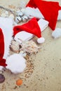 Three christmas hats on the beach. Santa hat the sand near shells. Family holiday. New year vacation. Copy space. Frame. Top view Royalty Free Stock Photo