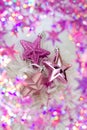 Three violet Christmas star ornaments framed by glittering chain.