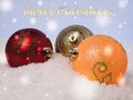 Lying on the snow multicolored Christmas tree decorations. With congratulatory text