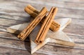 Three dry cinnamon sticks on decorated wooden star board