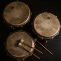 Three classical timpani drums are arranged on a dark surface. Each drum has a Royalty Free Stock Photo