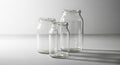 Three clear empty glass jars of varying sizes on a white surface transparent containers Royalty Free Stock Photo
