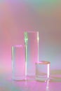 three clear glass cylinder podiums on pastel holographic colored background