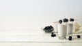 three glasses and a bowl of fruit sitting on a white table