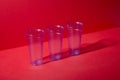 Three Clear Plastic Cups on Red Background with Copy Space Royalty Free Stock Photo