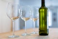 Three clear wine glasses and a bottle of chilled white wine on a Royalty Free Stock Photo