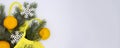 Three clementines in yellow eco string shopping bag with Christmas tree branch and snowflakes on white background with copying