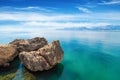 Three cliffs in sea with crystal clear water, blue sky and mountains on horizon near Antalya, Turkey Royalty Free Stock Photo