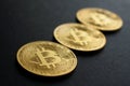 Three close-up bitcoin coins on black background