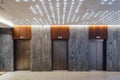 Three closed elevators in modern hotel lobby