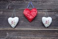 Three cloth heart symbols on old wooden wall