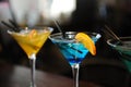 Three cocktails on the bar. Yellow, blue, green. Decorated with a lemon slice Royalty Free Stock Photo