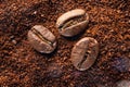 Three coffee beans lie on ground coffee close-up. Royalty Free Stock Photo