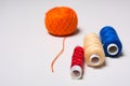 Three coils of multi-colored thread and a hank of orange Royalty Free Stock Photo