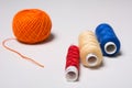 Three coils of multi-colored thread and a hank of orange Royalty Free Stock Photo